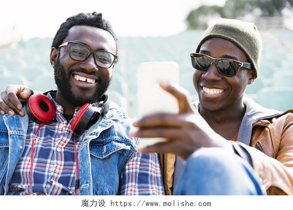两个黑人朋友玩手机朋友的概念